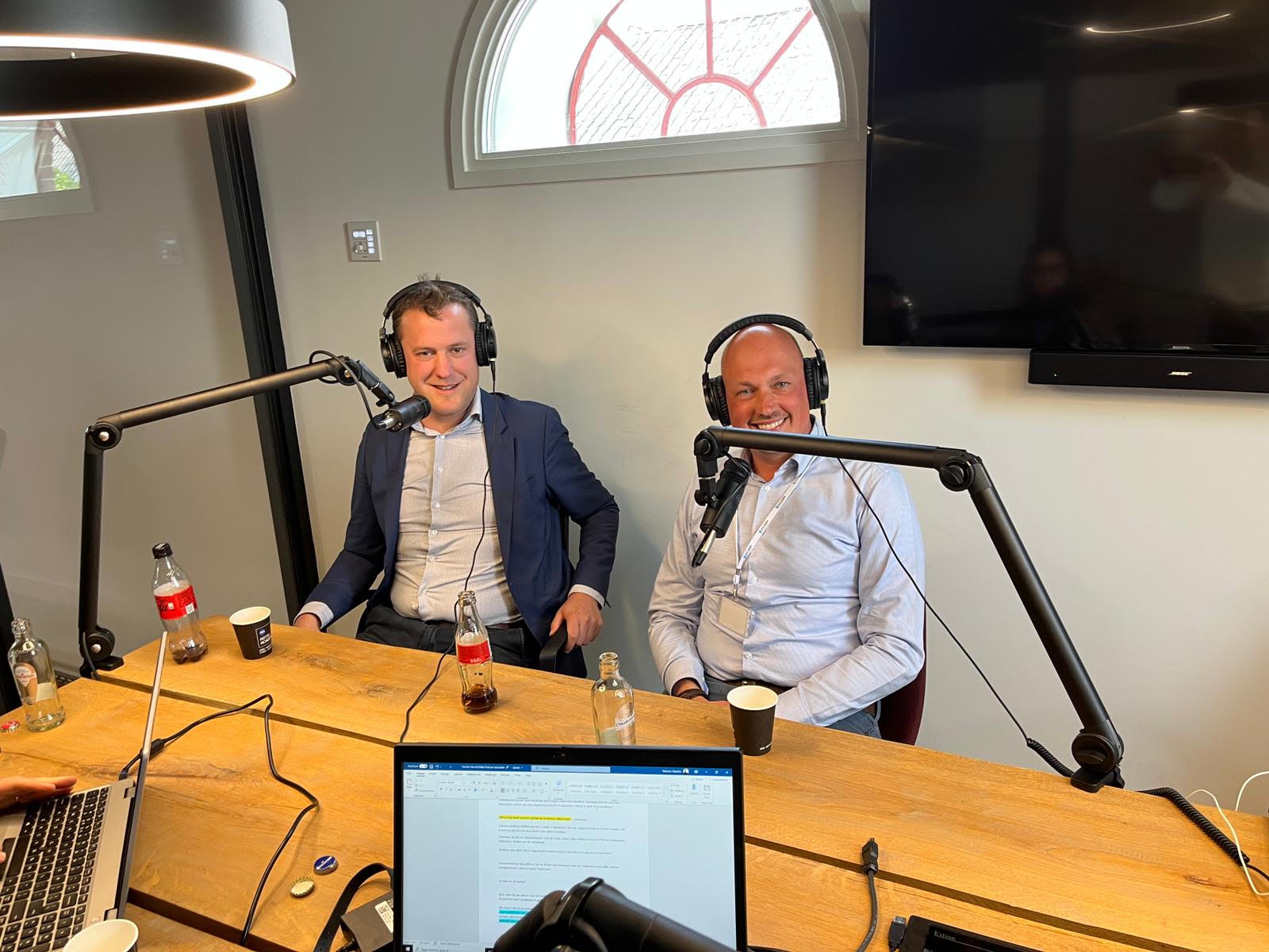 Tom de Haan aan de podcasttafel met microfoons tijdens een opname over cybersecurity