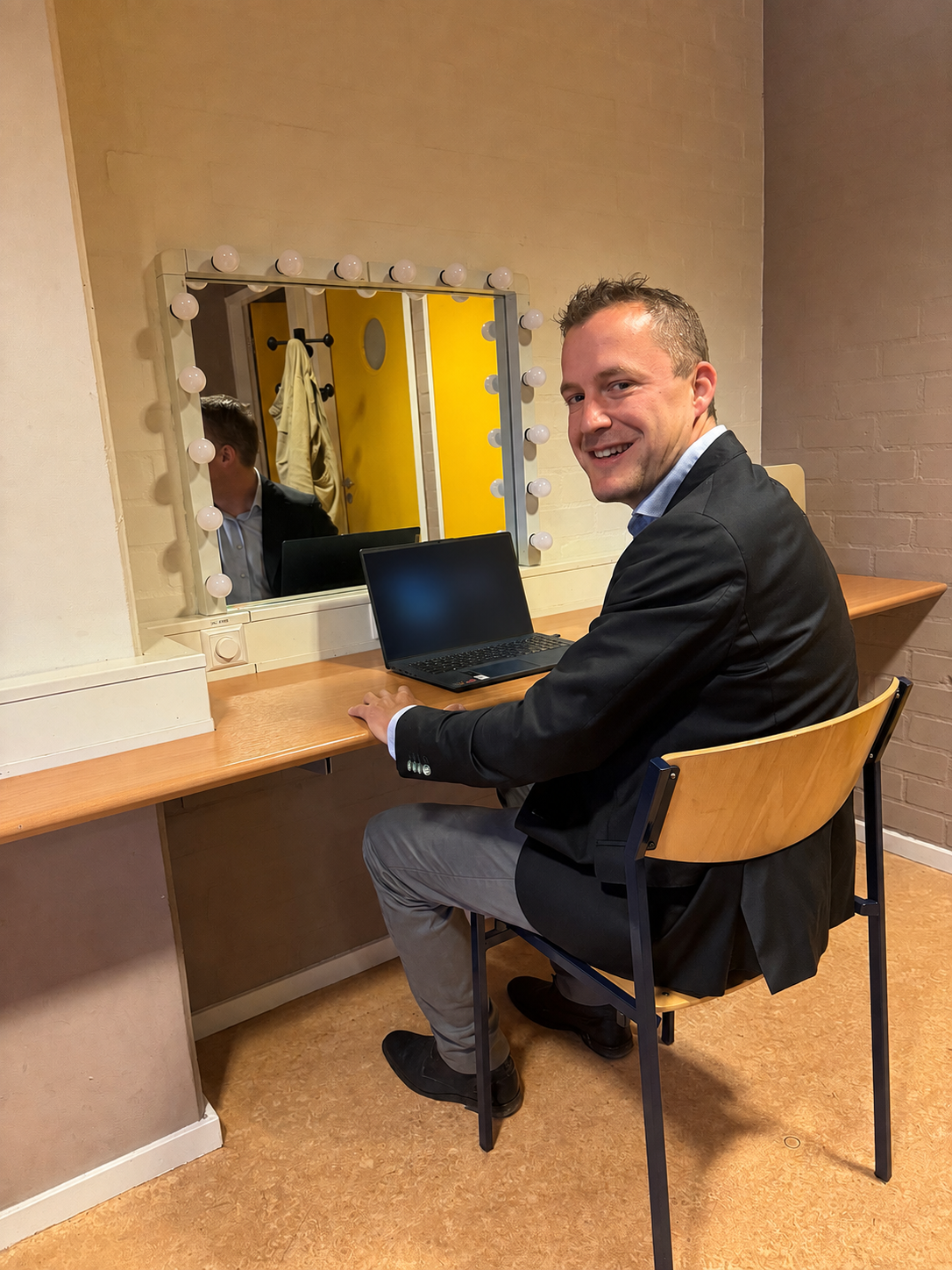 Tom de Haan bereidt zich backstage voor op een lezing